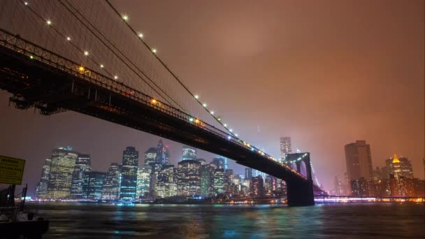 Бруклинский мост с видом на реку Ист-Ривер на Манхэттен ночью . — стоковое видео