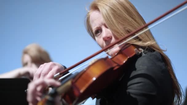 Жінка грає на скрипці в оркестрі відкритий — стокове відео