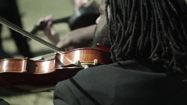 Hombre tocando el violín en una orquesta al aire libre — Vídeo de stock