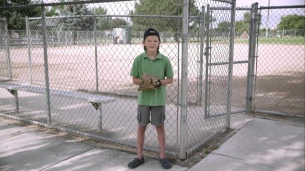 Menino batendo luva de beisebol, em seguida, girando e sorrindo . — Vídeo de Stock