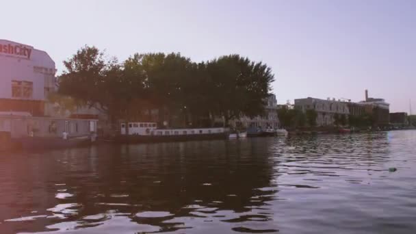 Puentes y edificios a lo largo del canal, con destello de lente en Amsterdam — Vídeos de Stock