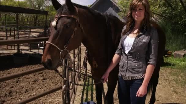 Девушка стоящая рядом с лошадью . — стоковое видео