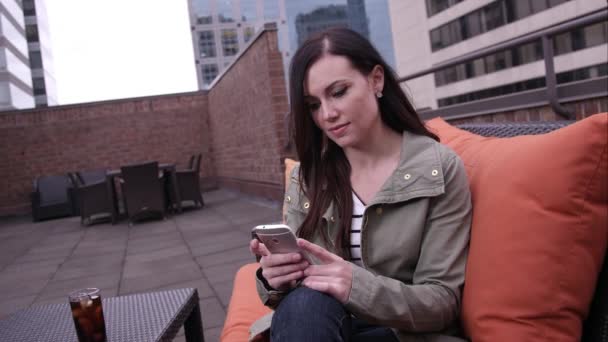 Woman answering smartphone on roof top. — Stock Video