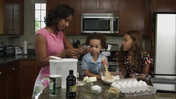Медленное перемешивание ингредиентов матери, мальчика и девочки . — стоковое видео