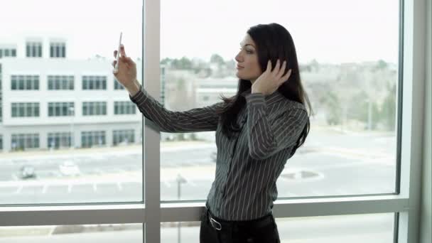 Woman taking selfie in front of windows. — Stock Video