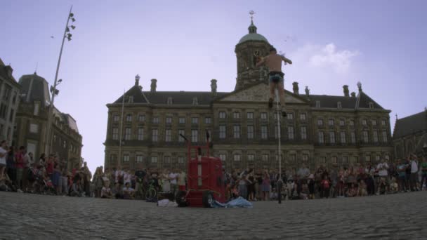 Жонглирование акробатом и балансирование на одноколесном велосипеде в Амстердаме — стоковое видео