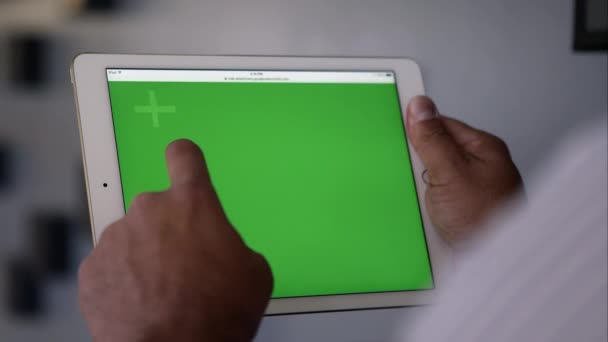 Visão de perto sobre o ombro da pessoa usando tablet com tela verde . — Vídeo de Stock