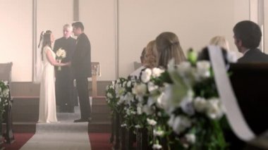 Gelin ve damat bir vaiz koridorda yürürken.