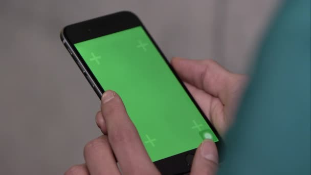 Iemand smartphone met groen scherm. — Stockvideo