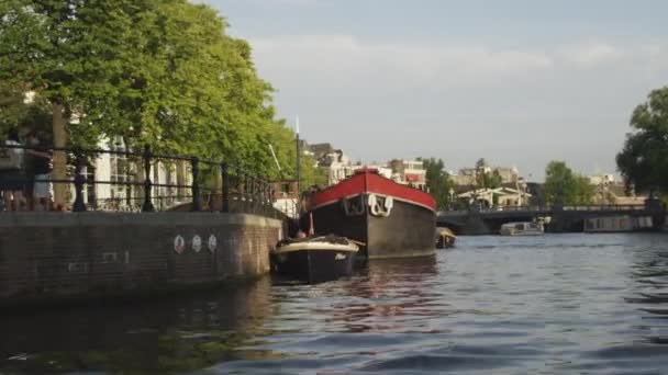 Tracking shot of people on the road and on a boat in Amsterdam, Países Bajos — Vídeos de Stock
