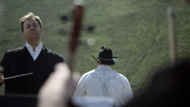 Man conducting in front of an orchestra — Stock Video