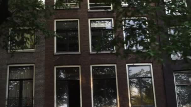 Tracking shot de fachadas bulding en Amsterdam, Países Bajos con destello de lente — Vídeo de stock