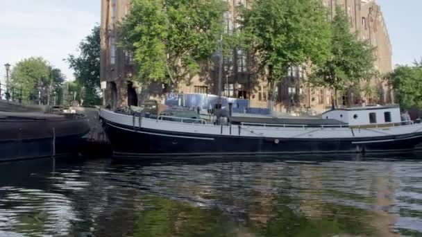 Spårning skott av byggnader och husbåtar längs Amsterdams kanal — Stockvideo