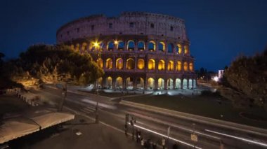Nighttime time-lapse of the Colosseum and street traffic.
