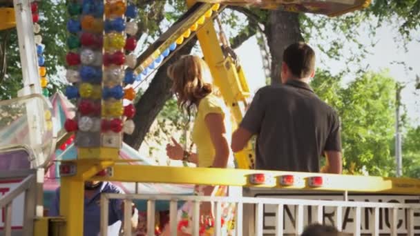 Pareja entrando en un paseo de carnaval — Vídeo de stock