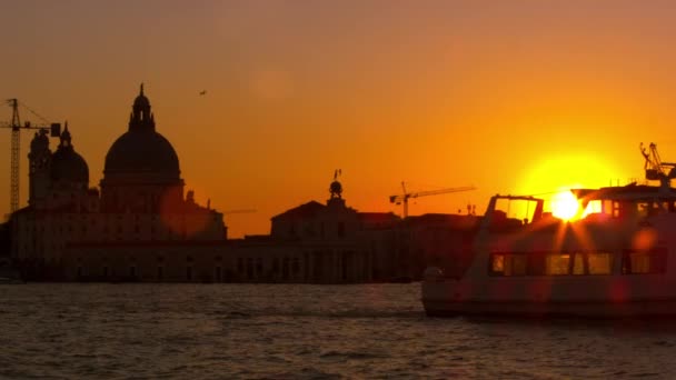 Lente llamarada de puesta de sol con el Santa Maria della Salute . — Vídeo de stock