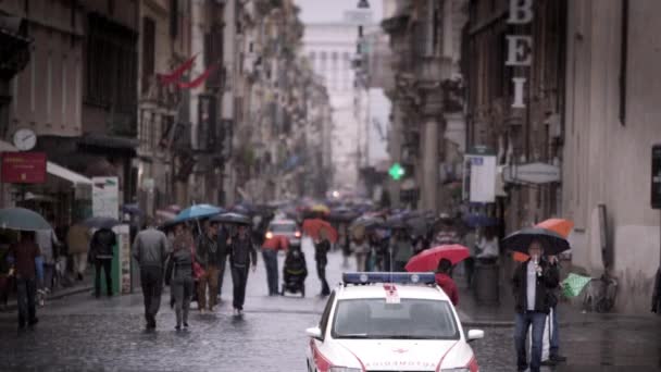 Slow motion beelden van wandelende mensen in een natte Romeinse straat — Stockvideo