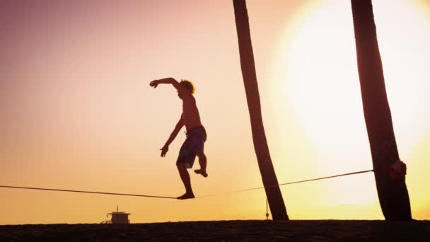 Man balansering på slackline nära Venice Beach — Stockvideo