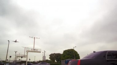 araba dolu bir yol üzerinde uçan uçak.
