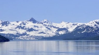 Glacier Bay boyunca karla kaplı dağlar