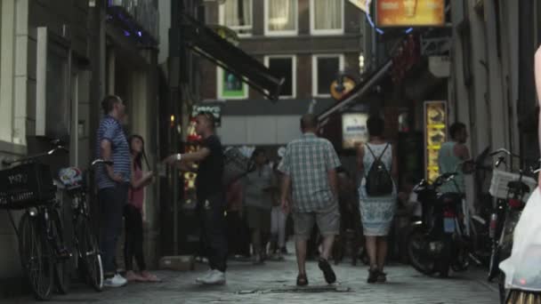 Foto estática de personas caminando y hablando en una pequeña calle de Ámsterdam — Vídeos de Stock