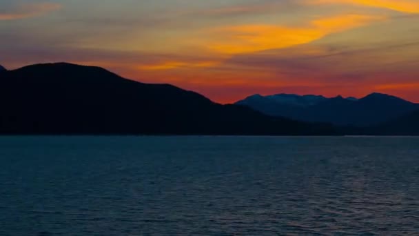 Sunset behind a silhouetted mountain ridge — Stock Video