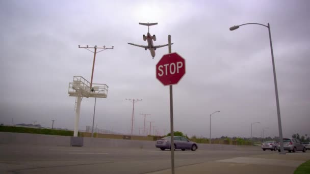 Vliegtuig vliegen over een weg vol met auto's. — Stockvideo
