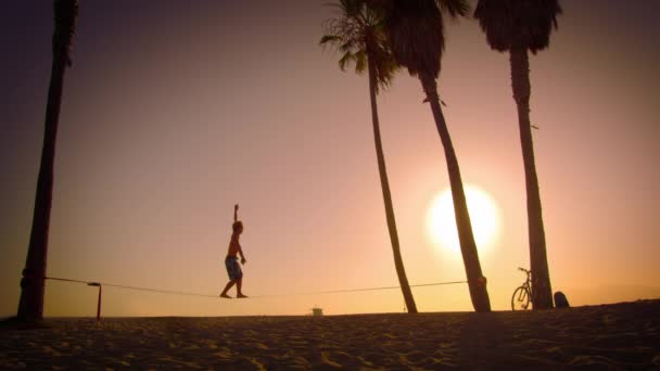 Hombre holgazaneando en la playa de Venecia en California — Vídeos de Stock