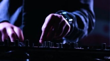 Yakın çekim görüntüleri karıştırma müzik bir partide denetim masasının kullanarak Djs eller bir erkek onun aracı bir aşamada müzik oynamak için sanatçı kullanıyor.