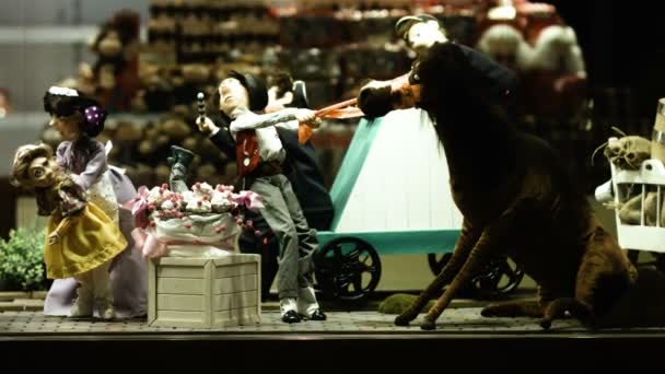 Muñecas exclusivas antiguas vintage se exponen en escaparate iluminado, persona indefinida que pasa por la ventana . — Vídeos de Stock
