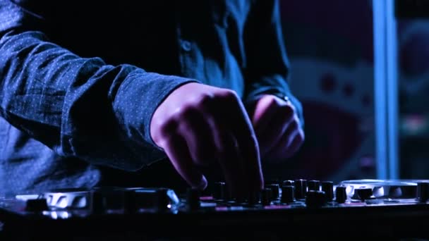 Imágenes de cerca de un hombre artistas de música manos empujando almohadillas y arañazos en un escritorio de control, DJ mezcla de música en el club nocturno . — Vídeos de Stock