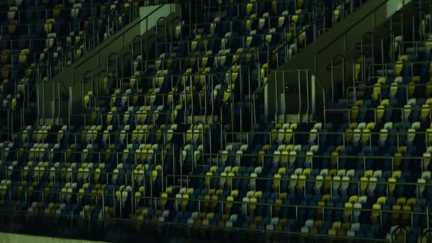 Imagem de assentos azuis e amarelos em um estádio com corrimãos . — Vídeo de Stock