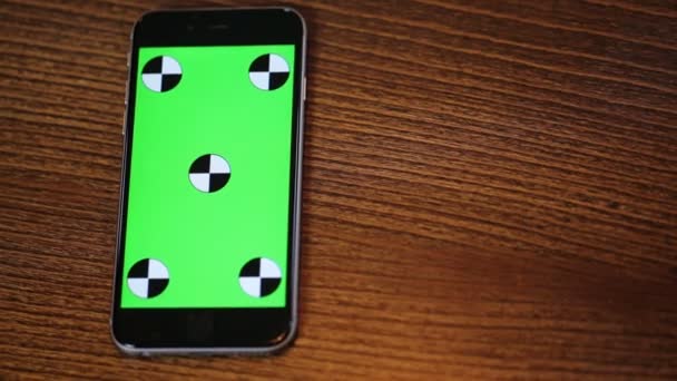 Vue aérienne du téléphone intelligent avec un écran vert sur une table en bois avec espace de copie — Video