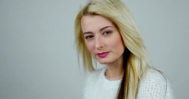 Seyir ve kameraya poz genç bir kadın portresi, üfleyici saçlarını taşımak için yapar..