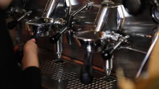 Close up of hands of young waitress preparing coffee in professional coffee machine in a cafeteria. — Stock Video