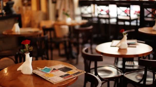 Menü boş bir restoranda taze kırmızı gül ile dekore edilmiş vintage ahşap masa üzerinde çıktı. — Stok video