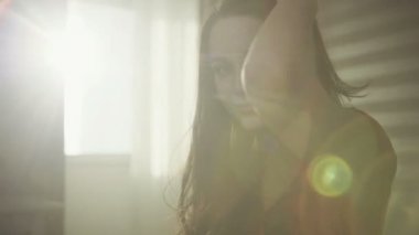 Sunny portrait of handsome young brunette female poses on camera.