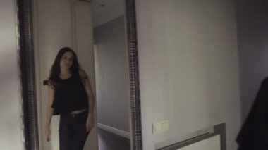 Slow motion footage how cheerful and happy girl spins before a mirror.