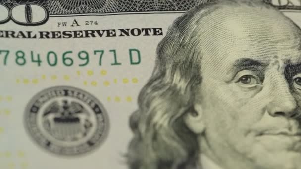 Contant geld achtergrond. Benjamin Franklin portret op 100 US dollar biljet close-up, het beeld is gedraaid — Stockvideo