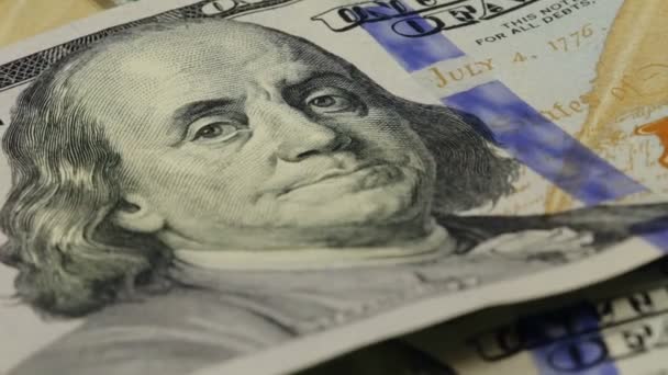 Деньги наличными. Портрет Бенджамина Франклина на 100 долларовой купюре крупным планом, изображение повернуто — стоковое видео