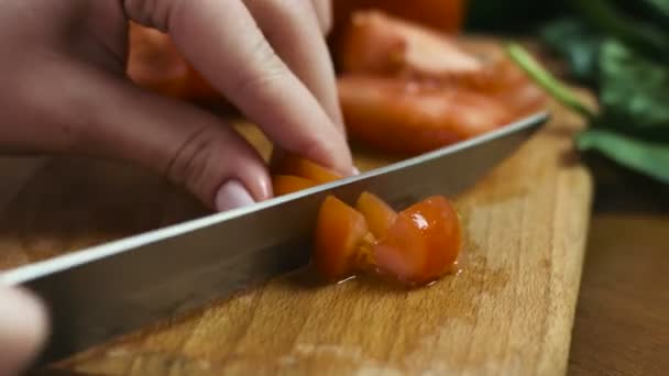 Close-up imagens de rastreamento de mãos femininas cortar um tomate com uma khife na cozinha . — Vídeo de Stock