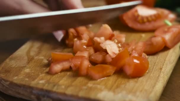 Close-up beelden van vrouwelijke handen snijden een tomaat op een houten plank, vrouw kookt een salade. — Stockvideo