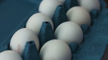 Bir düzine beyaz yumurta bir mavi karton kutu ve iplik etrafında yalan