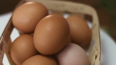 Bir düzine kahverengi yumurta etrafında dönen ahşap sepet içinde yakın çekim görüntüleri.