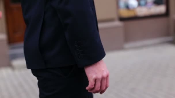 El novio a la moda vistiendo traje clásico negro caminar y la calle antes de la celebración de la boda comenzó . — Vídeo de stock