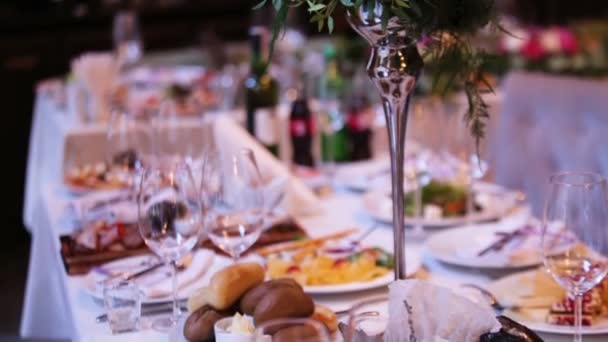 Mooie bruiloft decoratie gemaakt van bloemen van verschillende soorten en kleuren op de tafel van een bruiloft in een sjiek restaurant. — Stockvideo