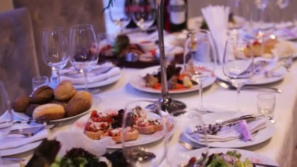 Hermosa decoración de boda hecha de flores de diferentes tipos y colores en una mesa de bodas en un restaurante de lujo . — Vídeo de stock