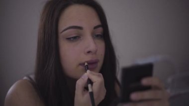 Esmer resim dudakları bir makyaj yapmak için mor kalem ile olan.