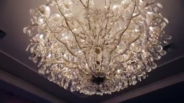 Bellissimo lampadario in cristallo strass di lusso retrò isolato su una parete bianca del ristorante . — Video Stock