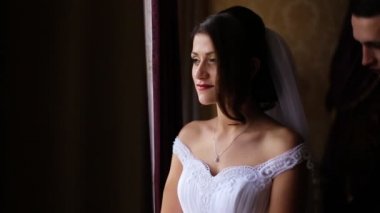 Genç güzel gelin stand yakın pencere ve onun yakışıklı damat omzunu dokun. Çok romantik bir atmosphera Oda.